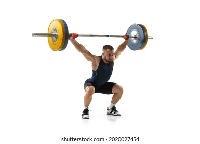 Full length portrait of man in sportswear exercising with a weight isolated on white background. Fit young muscular caucasian model with barbell training at abstract gym. Sport, weightlifting concept Foto stock