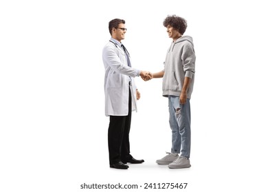 Стоковая фотография: Full length profile shot of a male doctor shaking hands with a young man isolated on white background