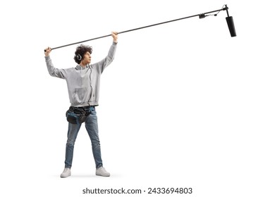 Full length shot of audio operator holding a microphone on set  isolated on white background: stockfoto