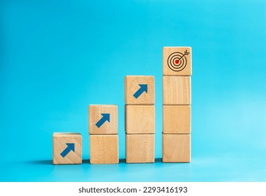 Goal and success. Arrow dart, target icon on top of wooden cube blocks, bar graph steps with up arrows. Business growth process, development, leadership, marketing, economic improvement concepts. Stockfoto