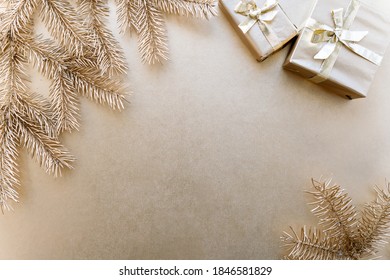 Golden Christmas or new year's background,plain composition of golden Christmas gifts and golden fir branches,Flatlay,empty space for greeting text.christmas concept. Stock Photo