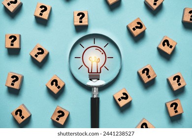 Glowing light bulb inside magnifier glass among question mark for focus and concentrate of creative thinking idea and problem solving concept.: stockfoto
