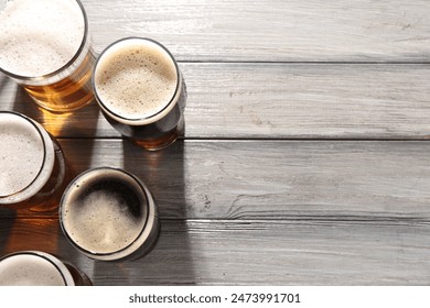 Glasses with different types of beer on grey wooden table, flat lay. Space for text – Ảnh có sẵn