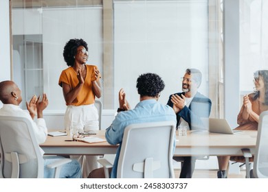Group of business people applauding and celebrating their successful teamwork, showcasing the spirit of collaboration and success in the workplace. Diverse business professionals working in a startup. Adlı Stok Fotoğraf