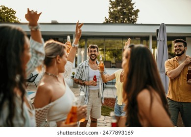 Group of diverse friends dancing and drinking during a pool party in a luxurious villa स्टॉक फ़ोटो