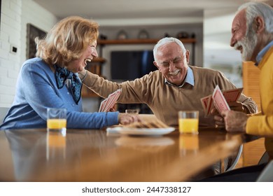 Group of happy seniors having fun while playing cards at home. 스톡 사진