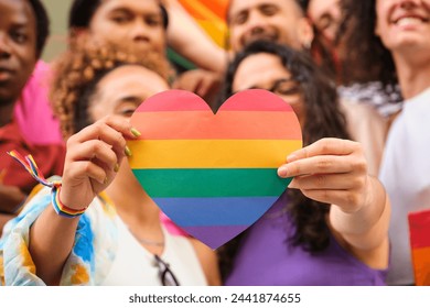 A group of LGBTQ people holding a rainbow heart celebrating International Pride Month.: stockfoto