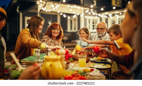 楽しい多民族の多様な人々のグループ，お互いに通信し、屋外ディナーで食べる。暖かい夏の夜に、家族や友人が家の外に集まりました。の写真素材