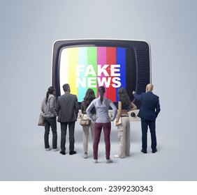 テレビで偽のニュースを見ている人々のグループは、古いテレビの前に立って画面を見ていますの写真素材