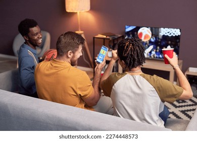 テレビで家庭でバスケットボールの試合を見たり、応援したりするスポーツファンのグループの写真素材
