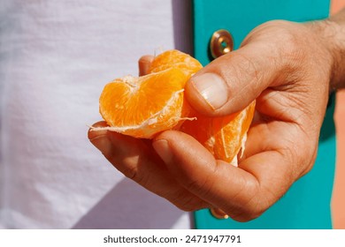 Hand of man holding slices of orange fruit Stock fotografie