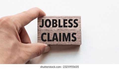 Hand of a businessman holding wooden blocks. Conceptual image. Text JOBLESS CLAIMS concept business succeed. 庫存照片