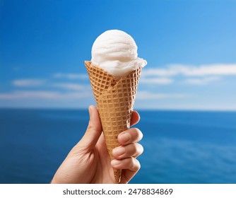 Hand holding Ice cream cone isolated on blue background, gelato, summer concept, abstract beach view 库存照片