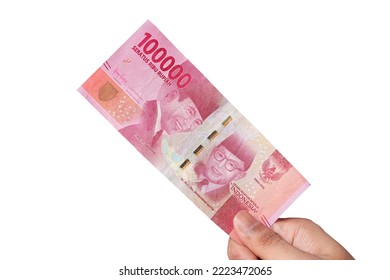 白い背景に10万ルピア紙幣を持つ手。財政概念の写真素材