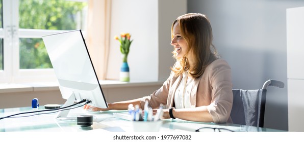 Handicapped Businesswoman Using Desktop Computer At Office Desk Stockfoto