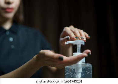 hands using wash hand sanitizer gel pump dispenser. Clear sanitizer in pump bottle, for killing germs, bacteria and virus. Stock Photo