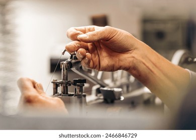 Hands working on a sewing machine in a detailed close-up Stock fotografie