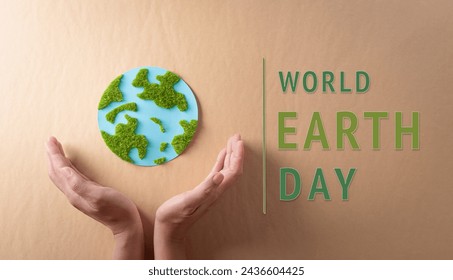 Hands holding paper earth with grass on brown background. World environment day, earth day and save earth concept.: stockfoto