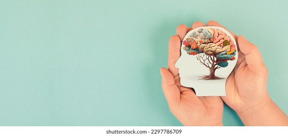 Hands holding paper head, human brain with flowers, self care and mental health concept, positive thinking, creative mind Foto stock