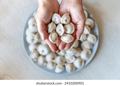 hands make dumplings, hands kneading dough, baker, Baker's hands, dough, hands in the flour, dumplings, handmade dumplings, ravioli view from above , 库存照片