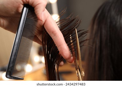 Hairdresser cutting client's hair with scissors in salon, closeup Stock-foto