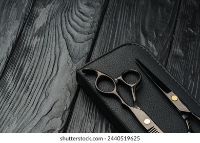 Hairdressing scissors on black wooden background close up Stock-foto