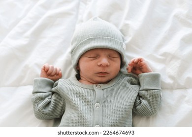 緑のクローラーとcap.Oneまたは2週間の古い、数日child.Copyスペースを着て眠って白鳥毛のブルネットかわいい新生児の半身ショット。の写真素材
