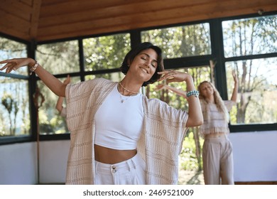 Happy young women community dancing moving together during spiritual practice meditation experience felling energy, peace and love. Dance healing holistic therapy concept. Stockfoto