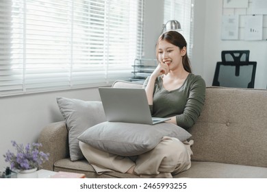 Happy asian woman waving during a video call on laptop at home. Work life balance concept Adlı Stok Fotoğraf