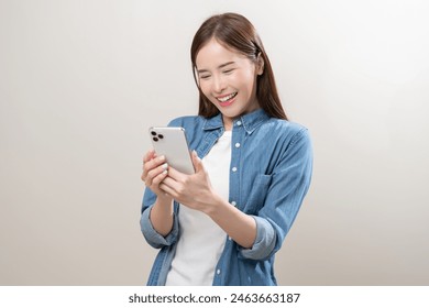 Happy asian young woman using mobile smart phone, read good news online, laugh excited getting offer, great positive surprise, celebrate success on smartphone. Smile girl isolated on white background. Foto Stock