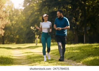 Happy athletic couple communicating while walking in nature after sports training. Copy space.  – Ảnh có sẵn