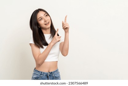 Happy beautiful young asian woman in white shirt pointing finger to copy space. Smiling female lady with blank space. Asian cute Pretty people looking copy space text advertise Arkivfotografi