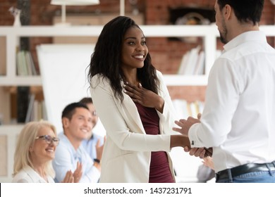Onnellinen musta naispuolinen työntekijä palkitaan ammatillisista saavutuksista kädenpuristus pomo, suvaitsevainen miesjohtaja kättele ylpeä afrikkalainen liikenainen edistää ilmaista tunnustusta työssä käsite Arkistovalokuva