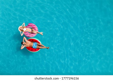 Happy couple with inflatable rings in swimming pool, top view and space for text. Summer vacation Stock Photo