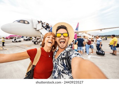 Happy couple of tourists boarding on a plane at the airport - Happy man and woman having happy summer vacation together - Transportation and holidays concept Foto stock