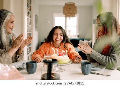 家で家族と一緒に誕生日を楽しんで祝うハッピーガールの写真素材