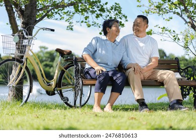 Happy and healthy couple Asian sitting chair beside a bicycle Family and friendship lifestyle, Enjoyment of active seniors, and outdoor activity after retirement, health care insurance concept Stock-foto