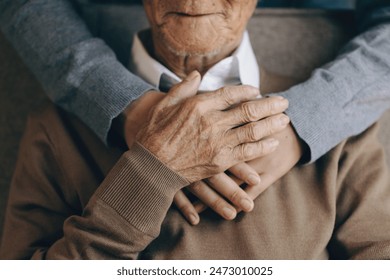 Happy healthcare worker hugging a senior man at home and support encouraging old people. A happy patient is holding the caregiver for a hand while spending time together. Elderly health care concept., fotografie de stoc