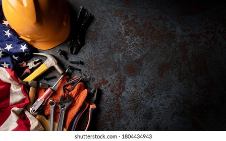 Happy Labor day concept. American flag with different construction tools on dark stone background, with copy space for text. Stock Photo