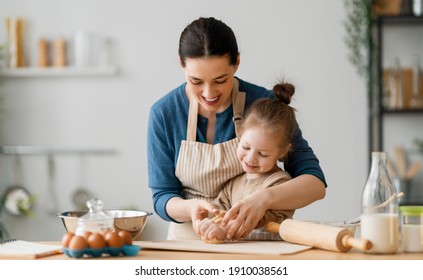 幸せな愛する家族が一緒にパン屋を作っている。 お母さんとお子さんの女の子は台所でクッキーを作って楽しんでいます。 手作りの食べ物と小さなヘルパー。    の写真素材