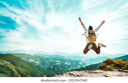 Happy man with backpack jumping on top of the mountain - Delightful hiker with arms up standing over the cliff - Sport and travel life style concept Foto stock