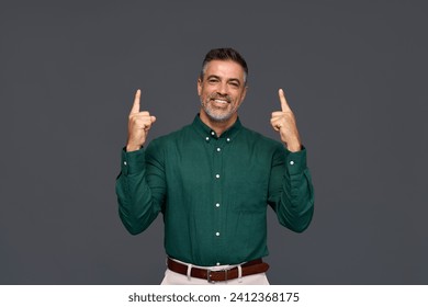 Happy middle aged business man entrepreneur, smiling older professional manager, confident businessman looking at camera pointing up advertising product or service isolated on gray background. Foto stock