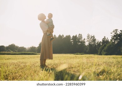 Happy mother with son enjoying nature on sunny day Stock Photo