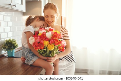 happy mother's day! child daughter congratulates mother and gives a bouquet of flowers to tulips
 Stock Photo