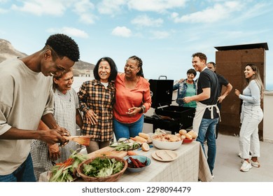 屋上でバーベキューを楽しむ多世代の幸せな人々 – 夏の集まりと食のコンセプトの写真素材