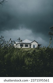 暗く不気味な雲の暗い嵐の中に隠された家の写真素材