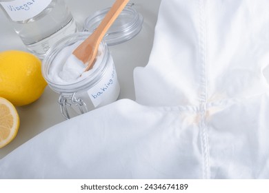 Homemade cleaning yellow sweat stains the armpits on a white T-shirt. Eco-friendly cleaning products white vinegar, baking soda, lemon. Embracing a zero-waste lifestyle. High quality photo 库存照片