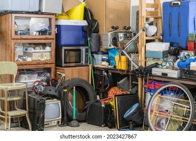 Hoarder clutter and household junk crowding the corner of a messy suburban garage.   Stock Photo