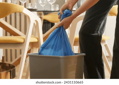 Ama de casa tirando la basura, sacando la bolsa de basura de plástico del contenedor de basura en el apartamento Foto de stock