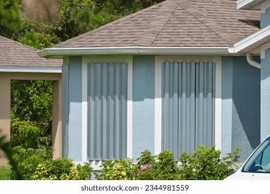 Hurricane shutters made from steel mounted for protection of house windows. Protective measures before natural disaster in Florida Foto stock